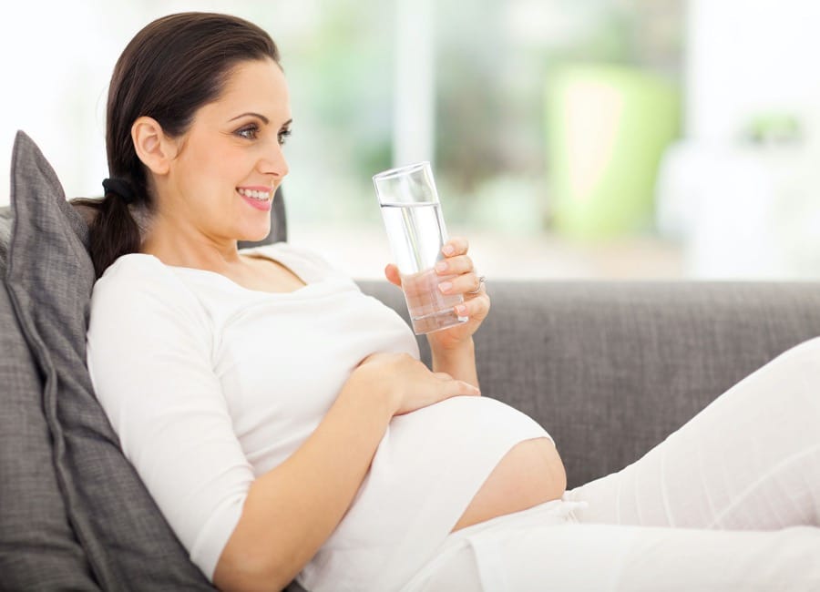 A pregnant woman staying hydrated for effective pregnancy exercise